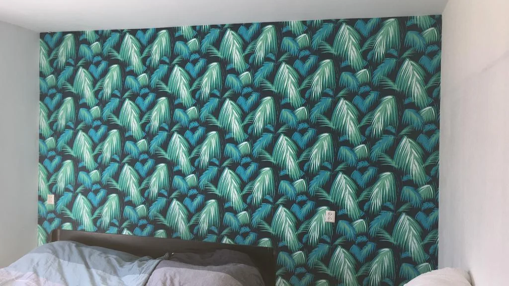 Botanisch patroon als accentwand in een slaapkamer.